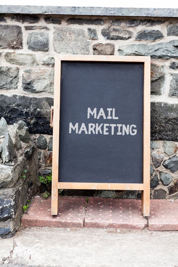 Sandwich Board with the words Mail Marketing written on it representing direct mail